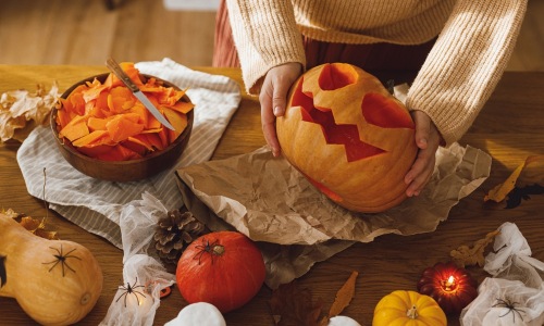 October Blog Woman holding a carved pumpkin
