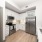 One-Bedroom Luxury Apartments In Naples, FL - The Pearl Founders Square Apartments - Gourmet Kitchen with Executive Chef Undermount Sink, Quartz Countertops, Wood-Finish Flooring, Designer Tile Backsplash, And Custom Shaker-Style Cabinetry with Wine Rack
